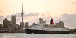 ID 1603 QUEEN ELIZABETH 2 (1969/70327grt/IMO 6725418) outbound at sunset from Auckland, New Zealand to continue her 2002/3 World Cruise.